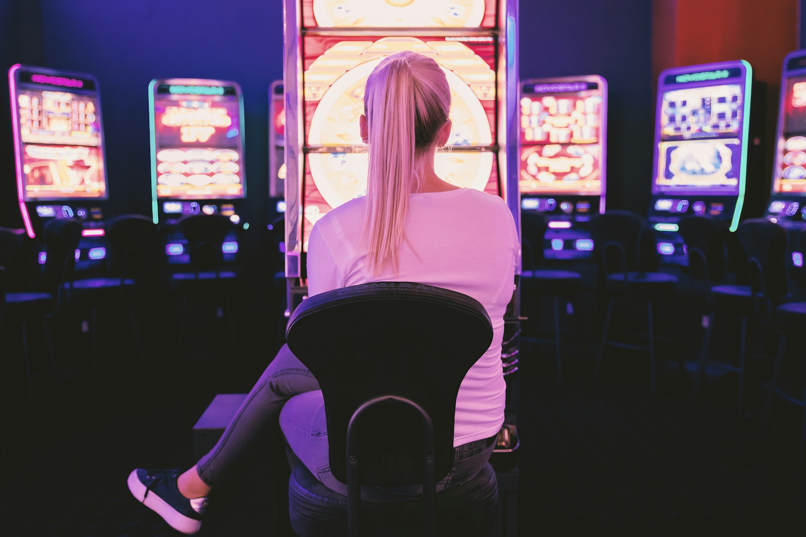 woman sitting facing a slot machine