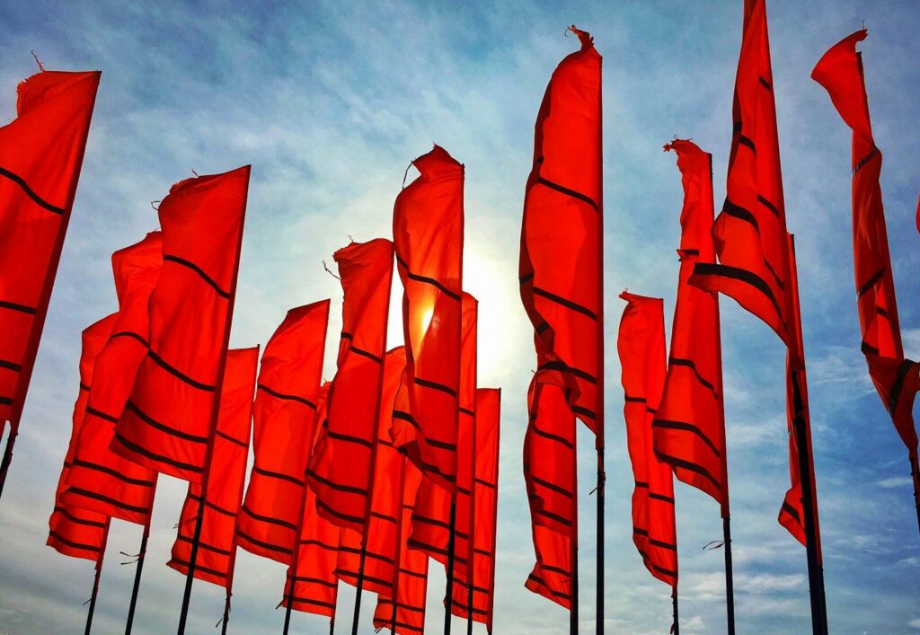 a bunch of red flags flying in the air